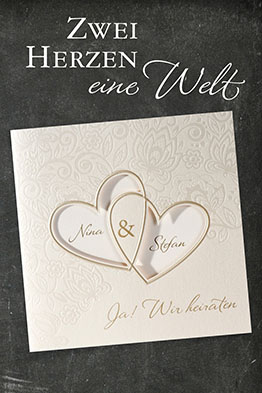 Elegante Hochzeitseinladungen mit zwei goldenen Herzen, Sichtstanzungen und Blumenmuster.