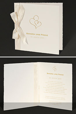 Aufgeklappte Hochzeitseinladung mit gedruckten Einladungstexten.