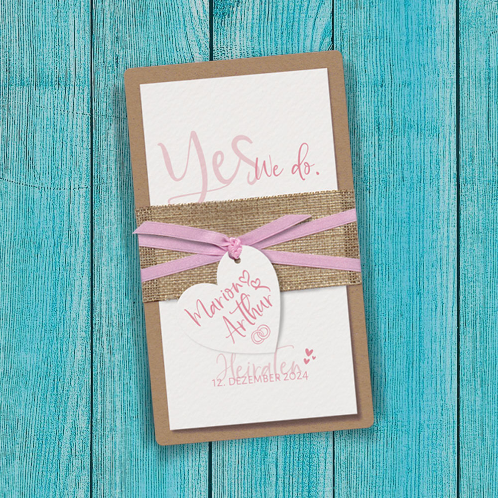 Einladungskarten zur Hochzeit oder Gartenhochzeit. Brauner Kraftkarton dient als Träger für eine klappbare Karte aus cremefarbenem Aquarellkarton. Banderole aus natürlicher Jute und einem rosa Satin-Bändchen.