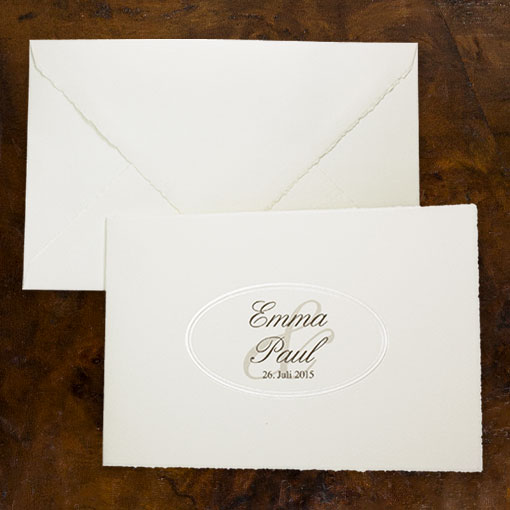 Cremefarbene Karte aus Büttenpapier mit typischem Büttenrand und ovaler Prägung in der Mitte.