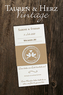 Weiße Hochzeitseinladungskarte mit brauner Kraftkarton-Banderole die mit einem turtelnden Taubenpärchen verzeirt ist.