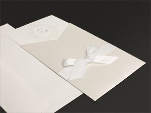Einladungskarten mit Kuvert vor grauem Hintergrund.